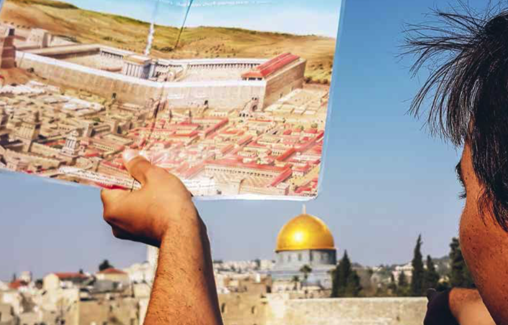 Israël, Jérusalem. Un homme tient un poster représentant le Temple de Salomon devant le dôme du Rocher de Jérusalem et le Mur des Lamentations. Photo: Mahesh Shantaram / Agence VU