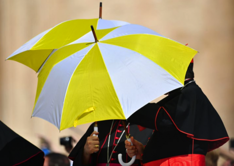 Un cardinal et un évêque sous un parapluie attendant le pape François sur la place St-Pierre au Vatican. Photo by VINCENZO PINTO/ AFP via Getty Images